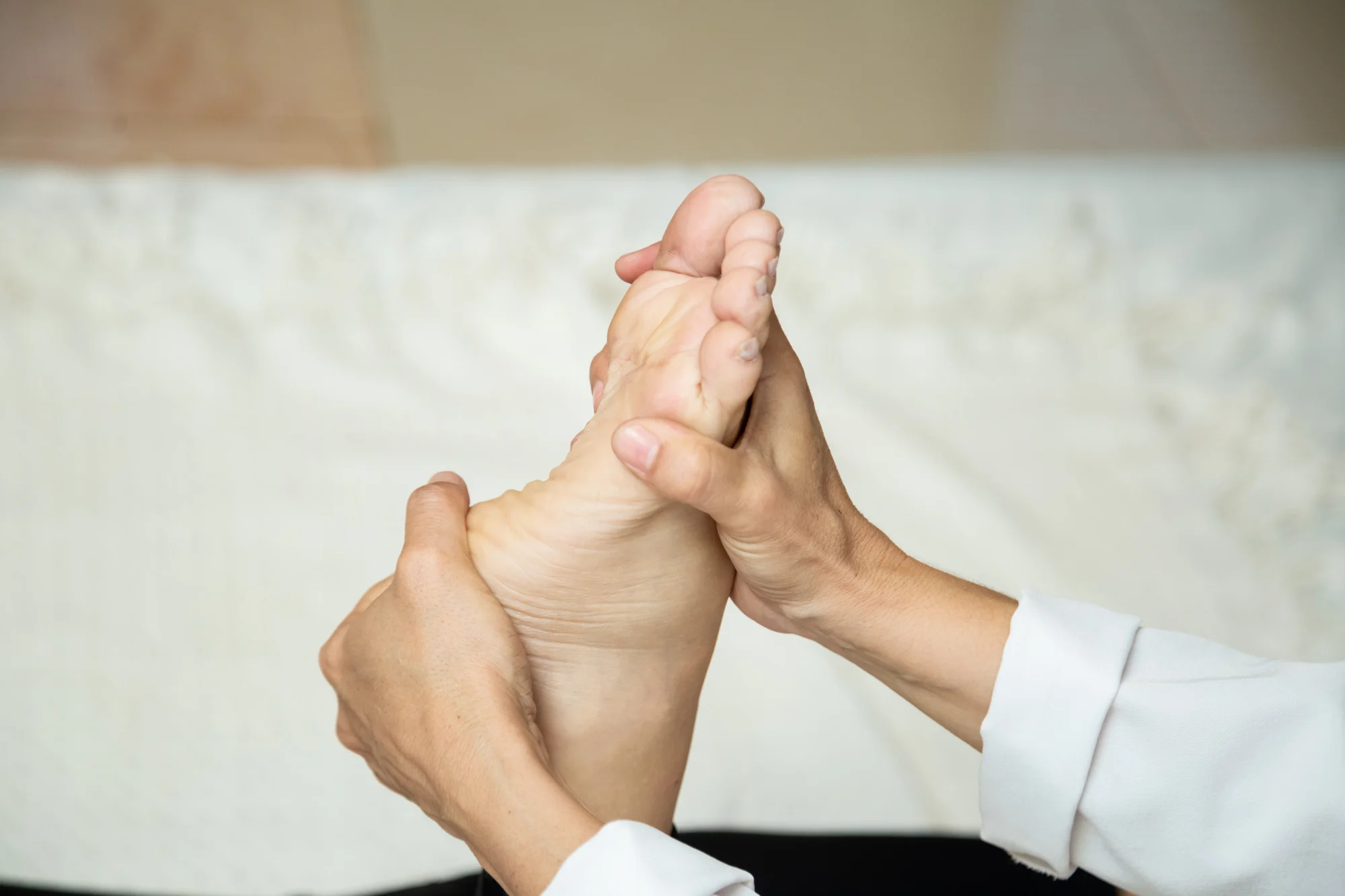 Terapeuta do Espaço Cor aplicando reflexologia nos pés de uma cliente
